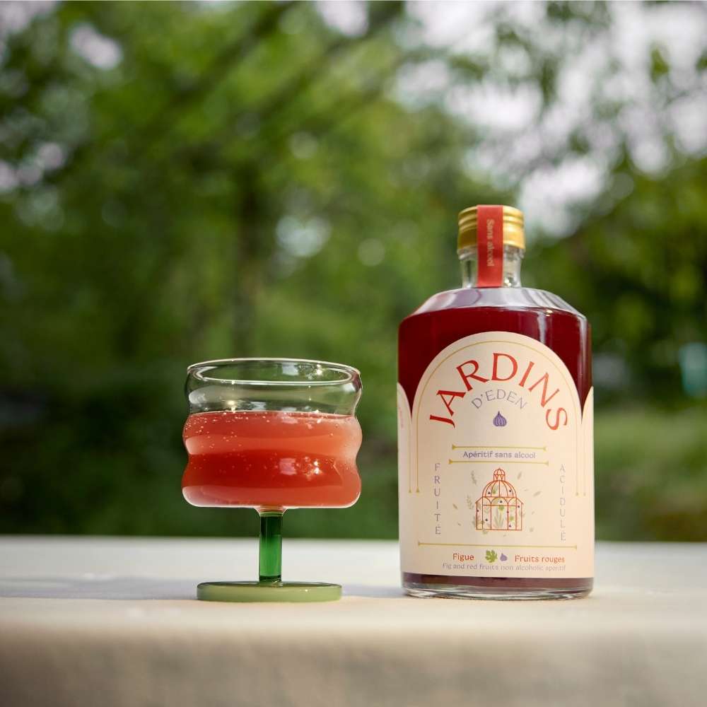 
                  
                    bouteille d'apéritif sans alcool pour réaliser des cocktails sans alcool à la figue et aux fruits rouges avec un verre
                  
                
